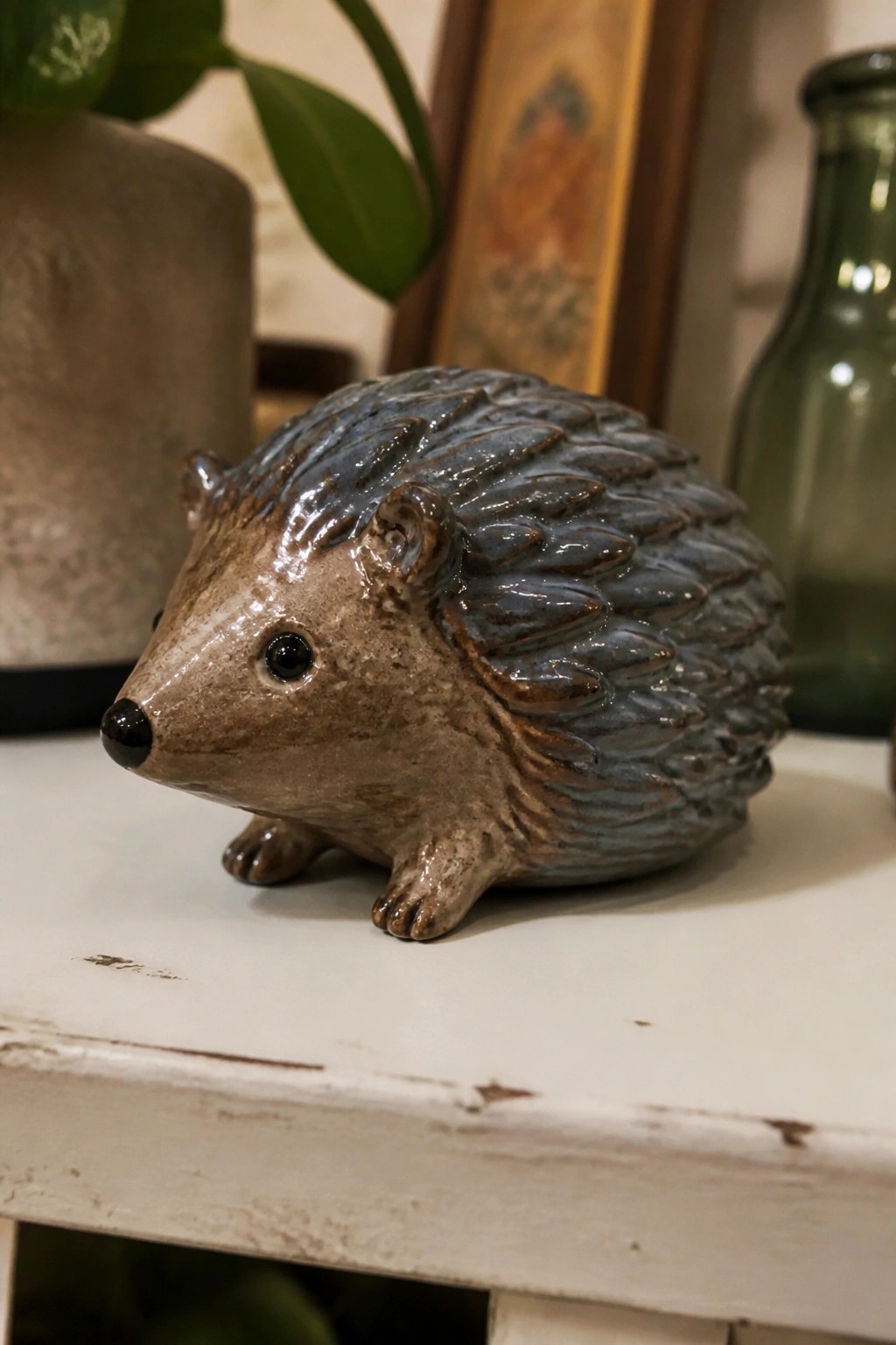 Ceramic hedgehog figurine with brown body and blue-gray spines on white table