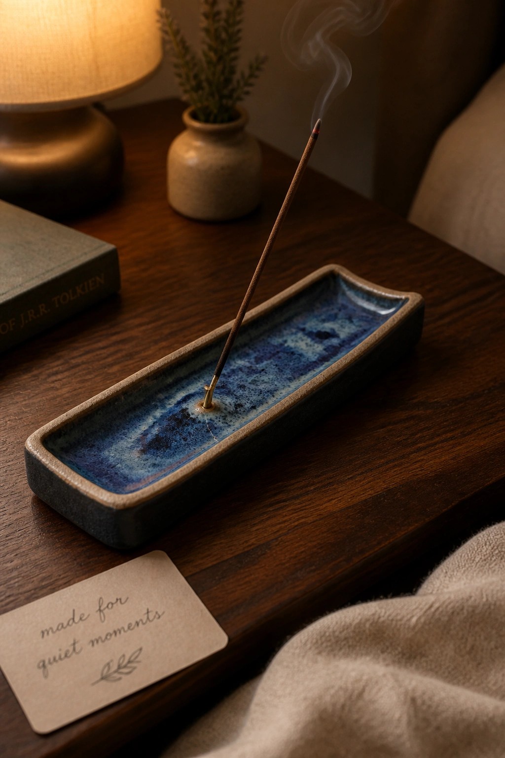 Burning incense in blue ceramic holder beside quiet moments card on wooden table