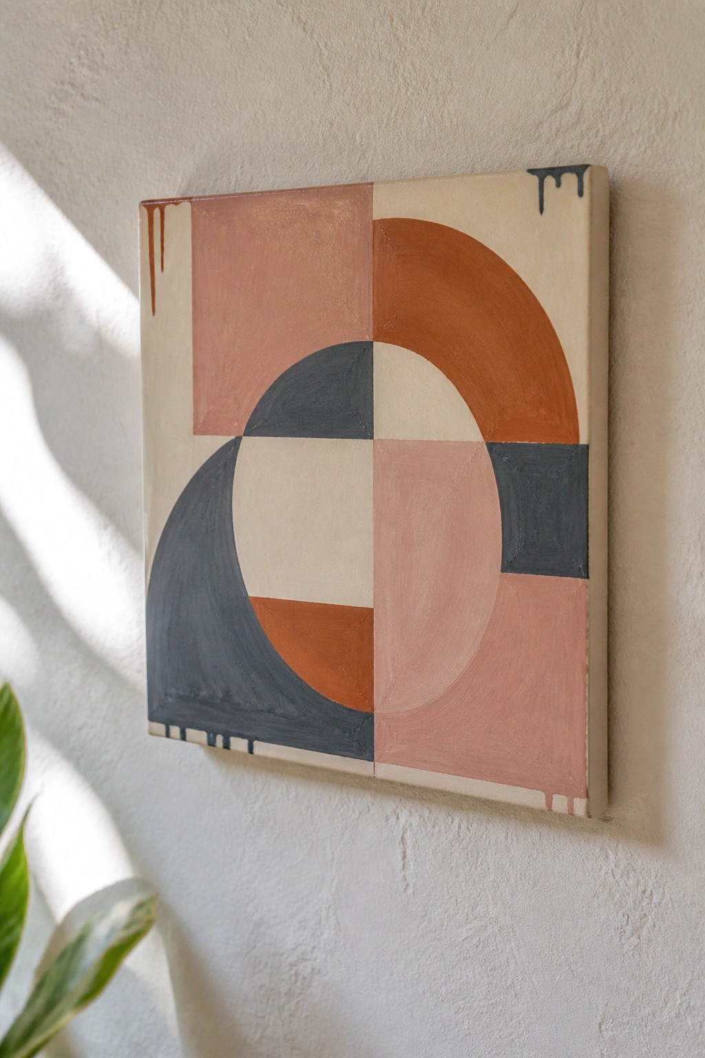 Abstract geometric painting with circles and squares in earthy tones and paint drips on wall