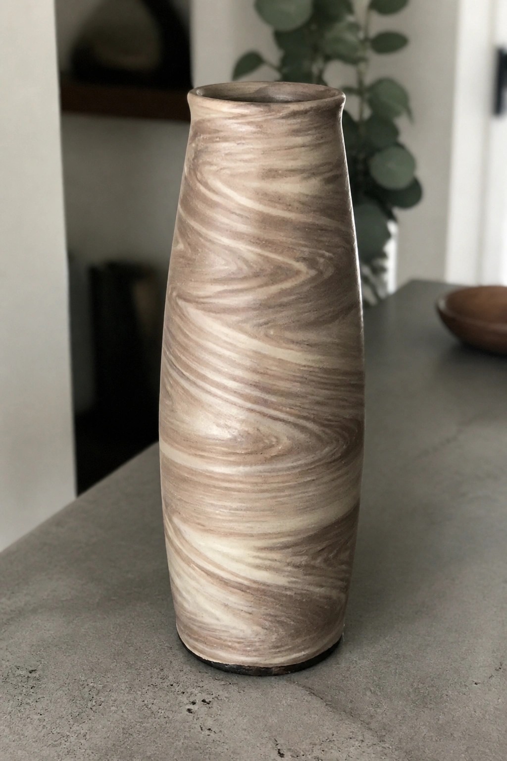 Tall marbled ceramic vase with swirling beige and brown patterns on gray table
