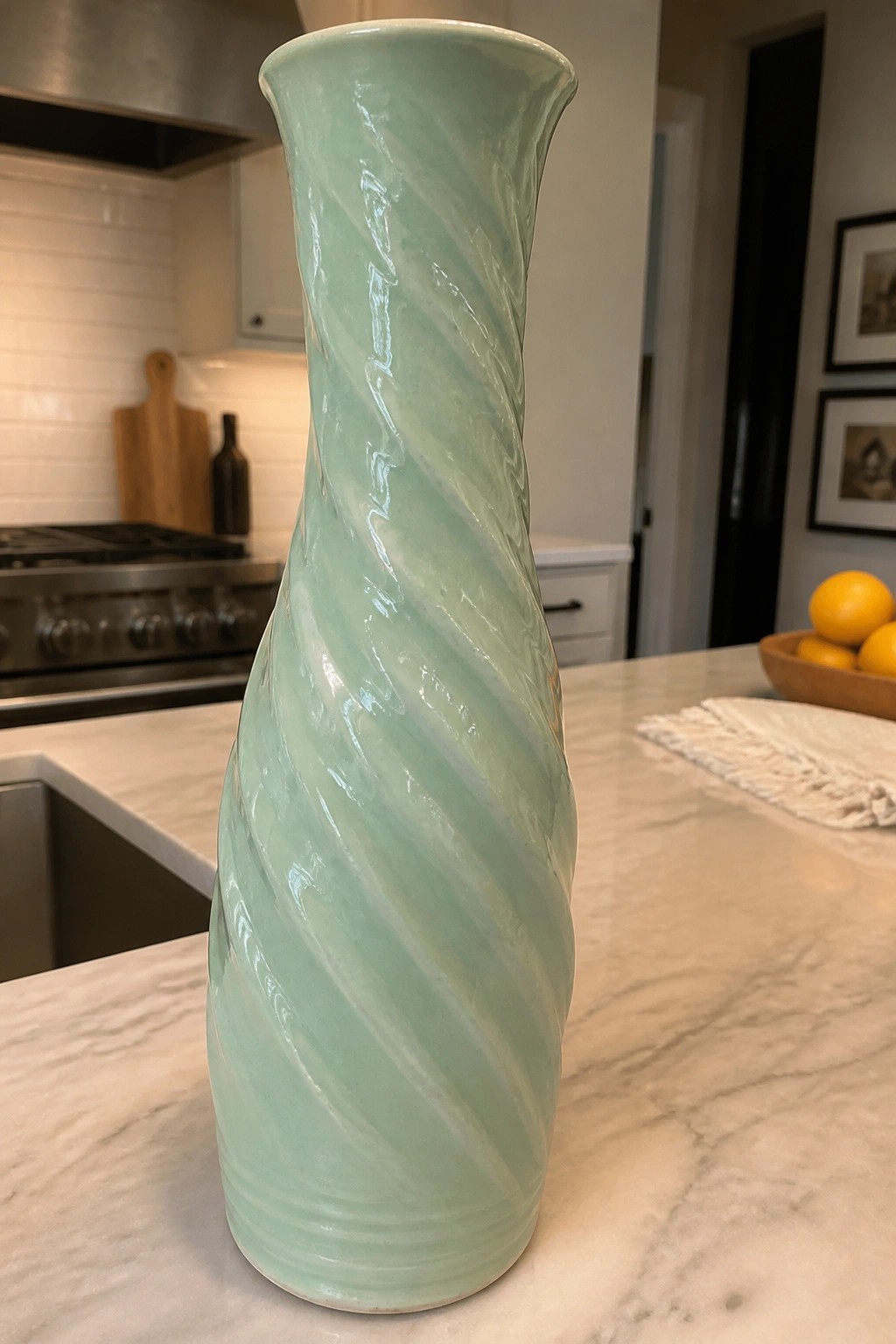 Mint-green twisted ceramic vase on marble kitchen countertop with lemons nearby.