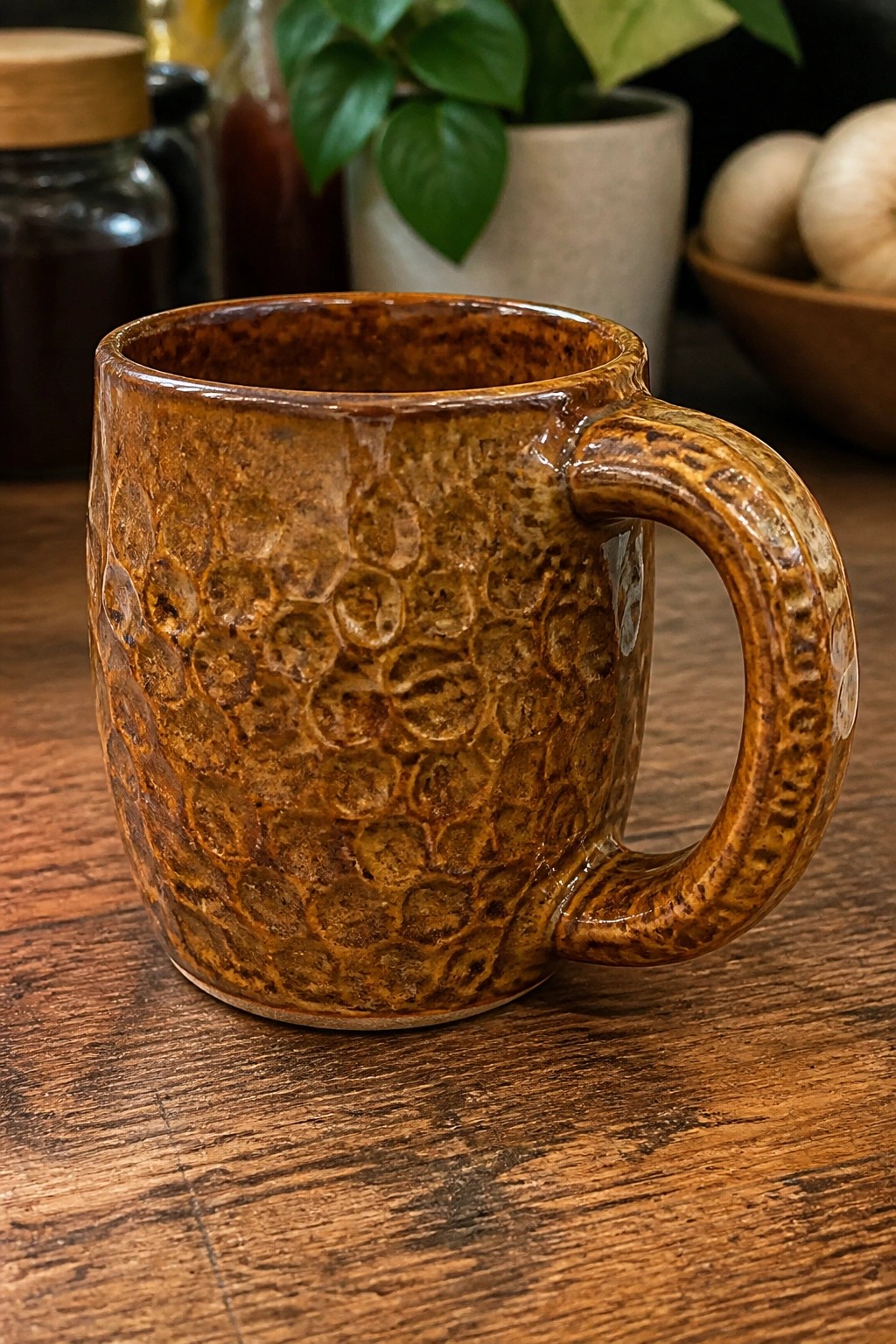 Brown dimpled ceramic mug with handle on rustic wooden table in kitchen