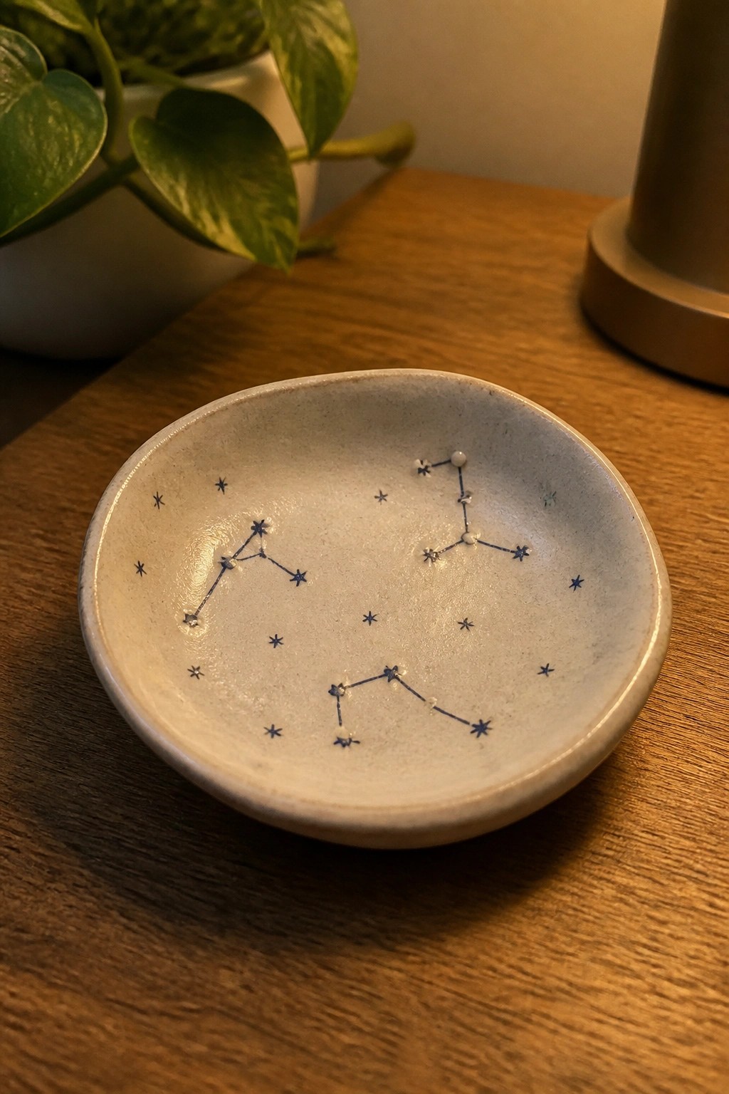 Small white ceramic bowl with blue constellation designs on wooden table