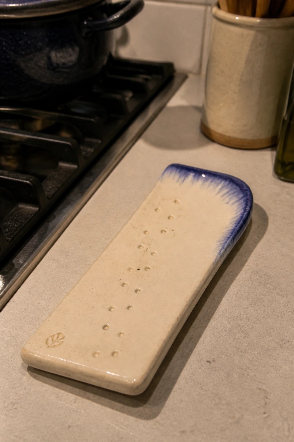 Rectangular off-white ceramic tray with blue rim and dots on kitchen counter