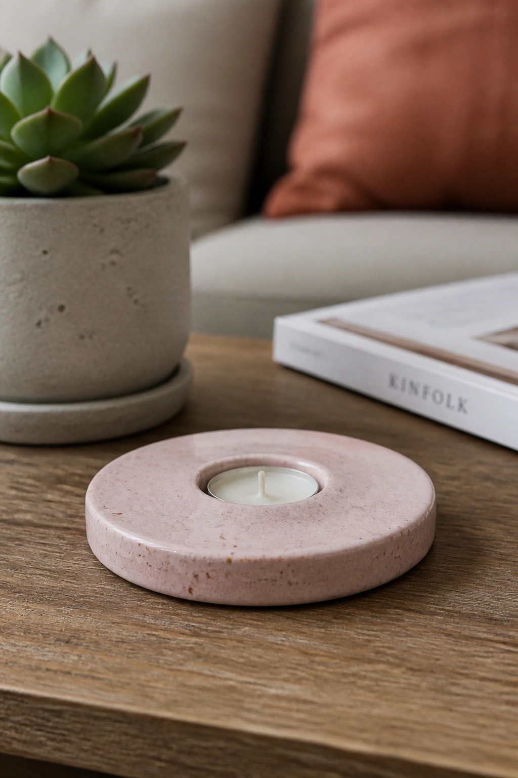 Pink terrazzo tealight candle on wooden table beside succulent and Kinfolk book