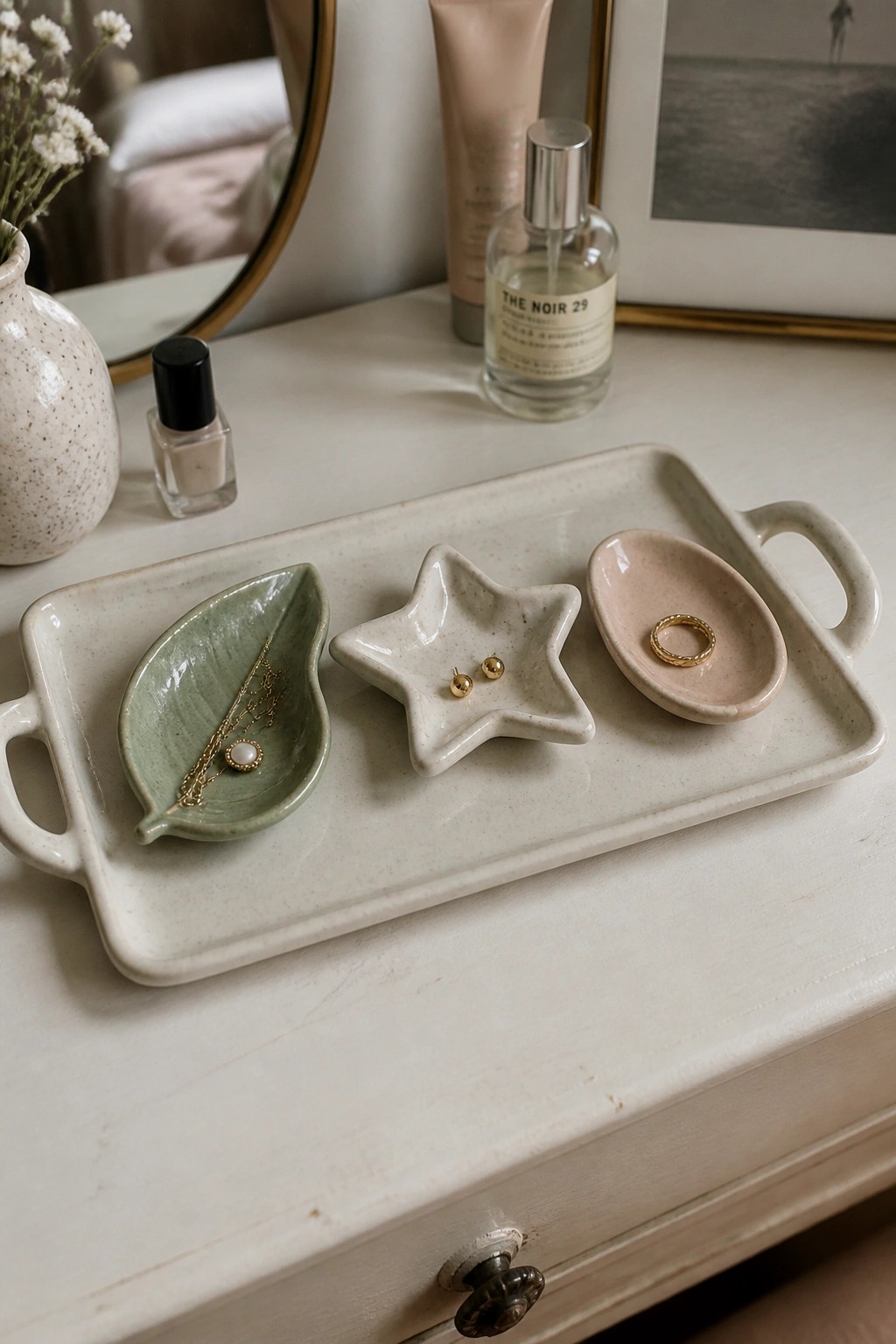 Ceramic tray with leaf, star, and oval jewelry dishes on white dresser