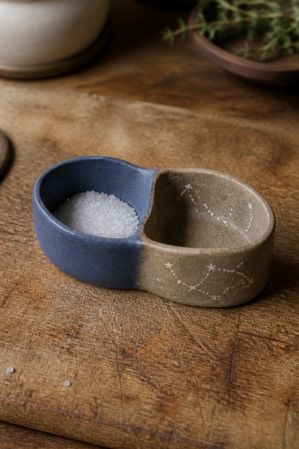 Blue-brown two-section ceramic bowl with salt and constellation etchings on wood