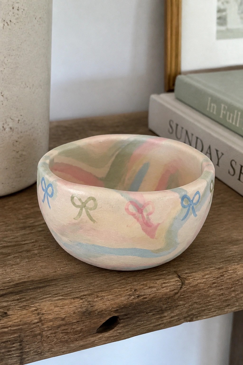 Pastel marbled bowl with colorful bows on rustic wooden surface