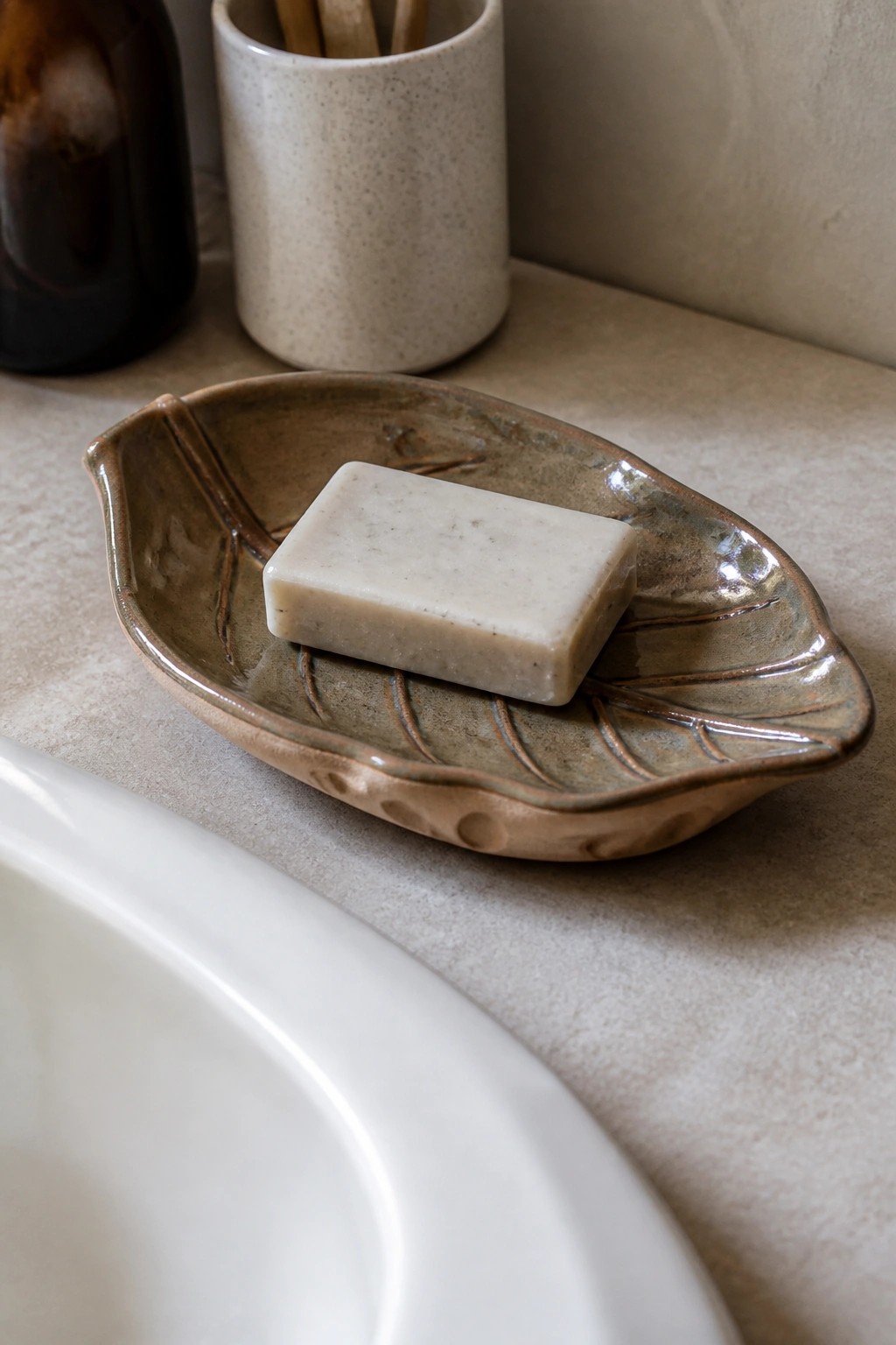 Leaf-shaped ceramic soap dish with bar of soap on bathroom countertop