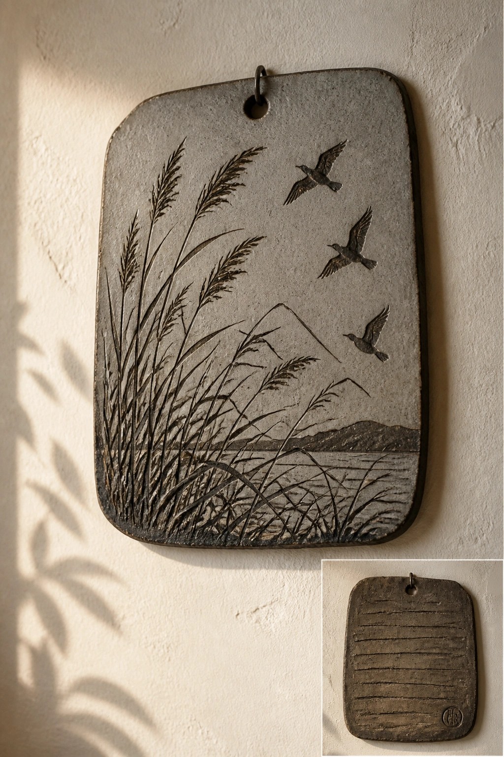 Gray rectangular plaque with relief of reeds, flying birds, mountains and water, reverse inset.
