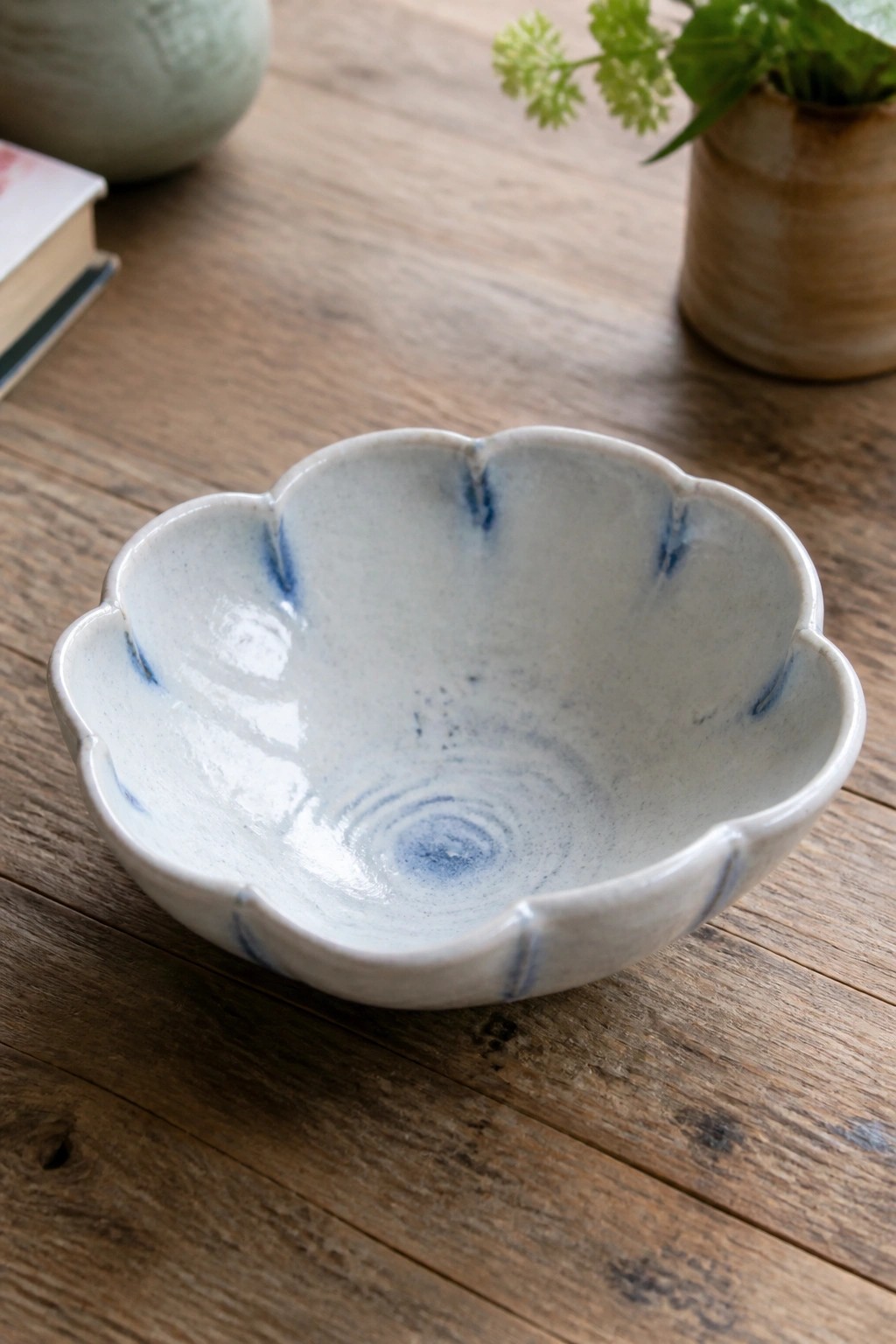 Scalloped ceramic bowl with blue accents on rustic wooden table