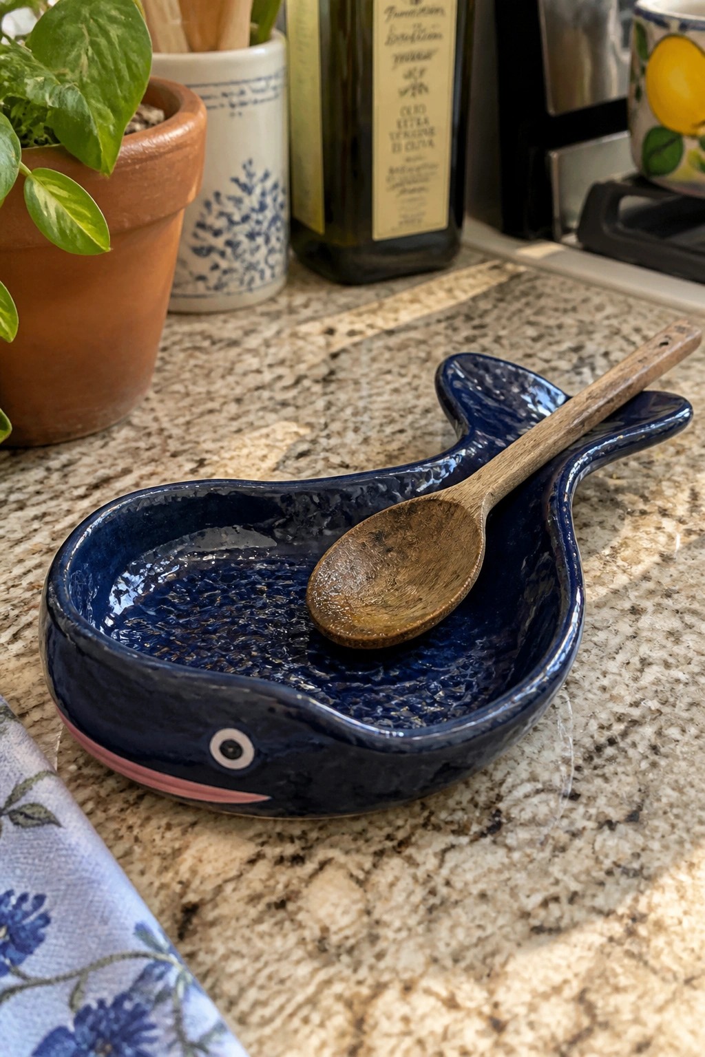 Blue whale ceramic dish holding wooden spoon on granite kitchen counter