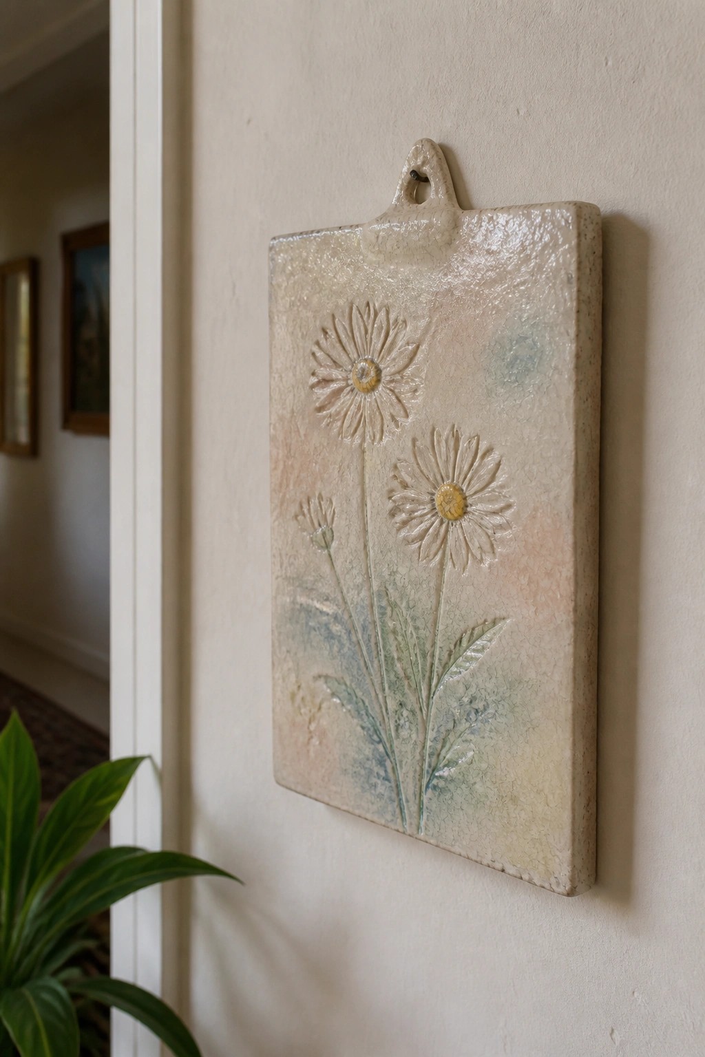 Ceramic plaque with embossed daisies and crackled pastel glaze on wall