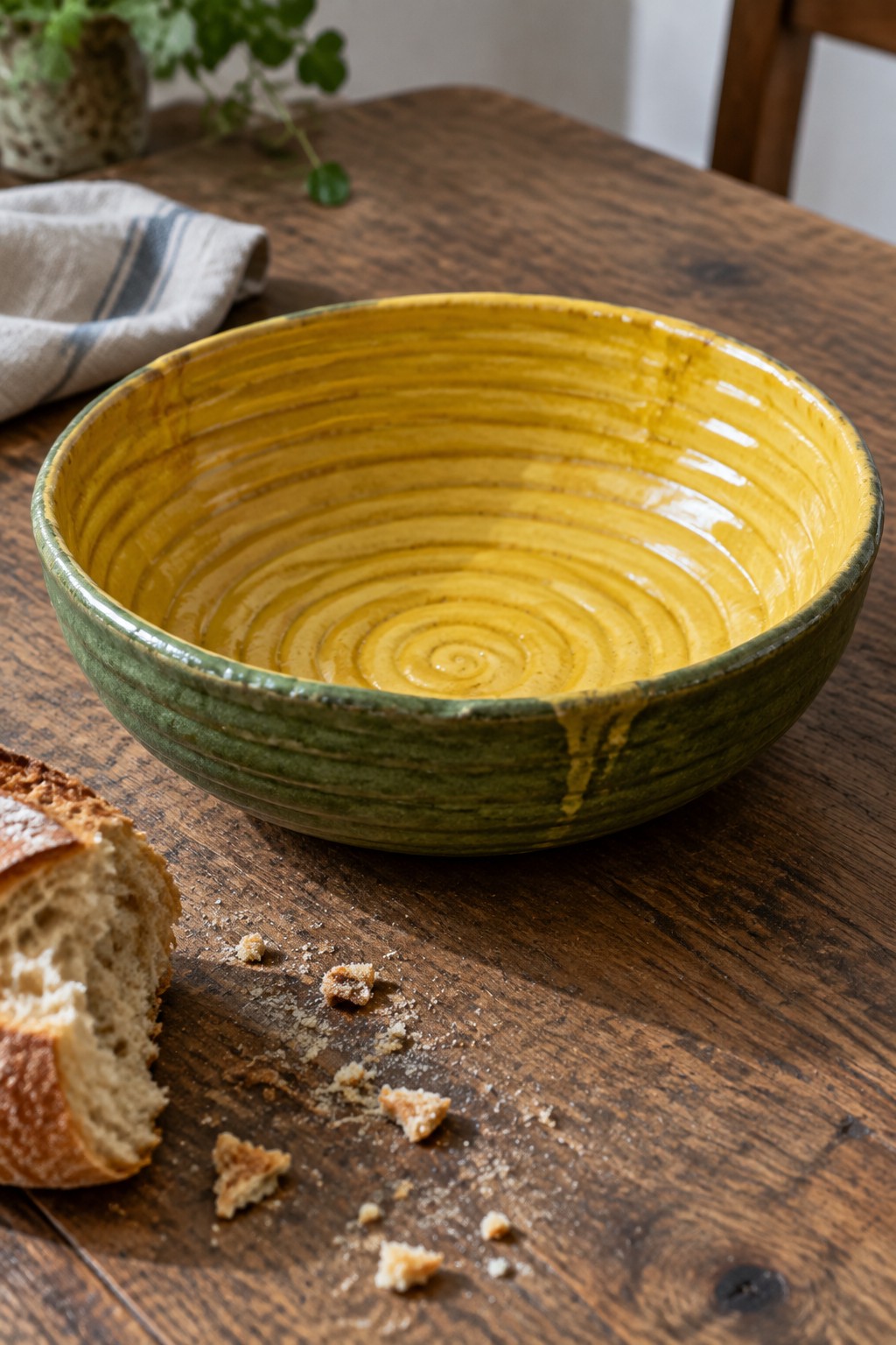 Yellow-green ceramic bowl with bread crumbs on rustic wooden table