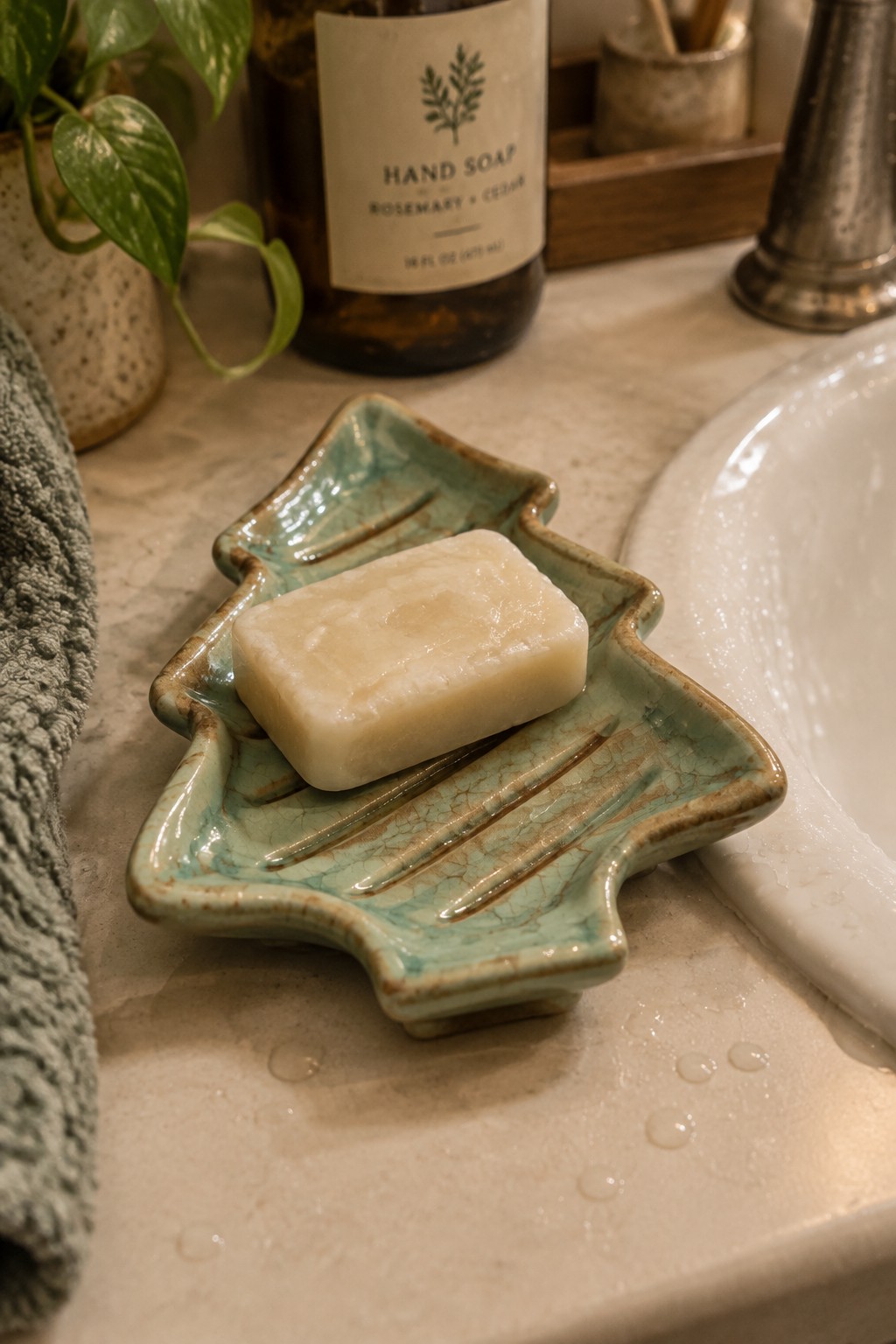 Creamy soap bar on turquoise ceramic dish beside bathroom sink and towel
