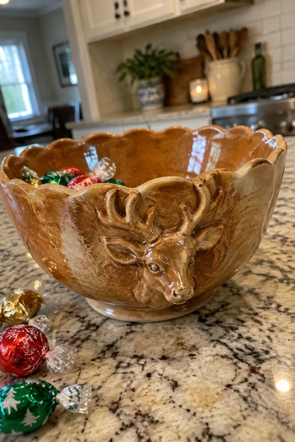 Brown ceramic deer bowl with wrapped Christmas candies on granite countertop