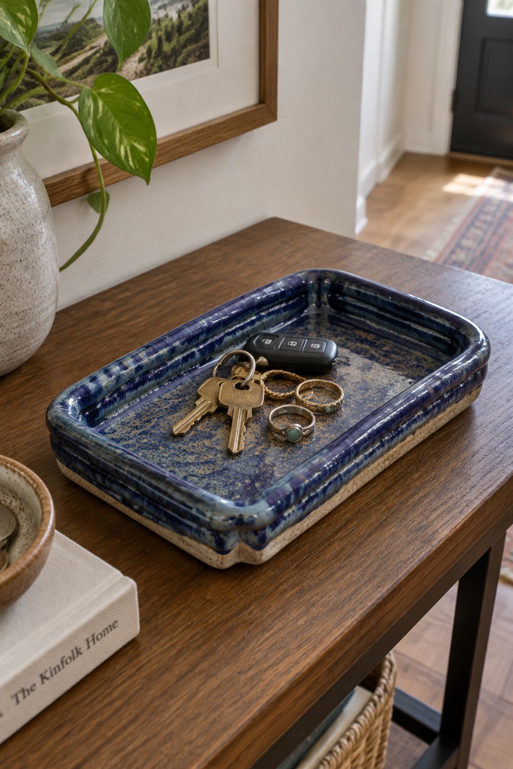 Keys and rings in a blue speckled ceramic tray on a wooden table